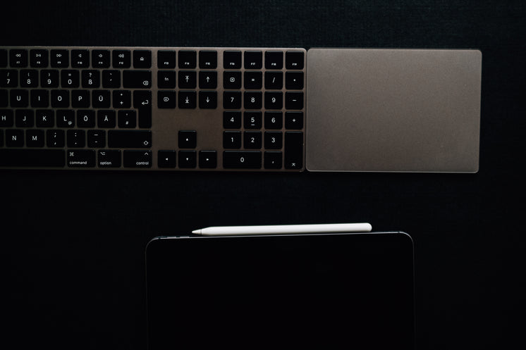 A Keyboard And Tablet On A Black Surface