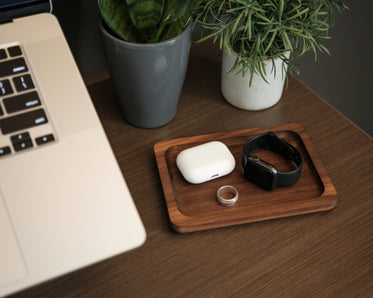 a laptop with potted plants and wooden tray