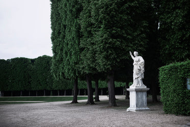 a large statue sits in a grove of trees
