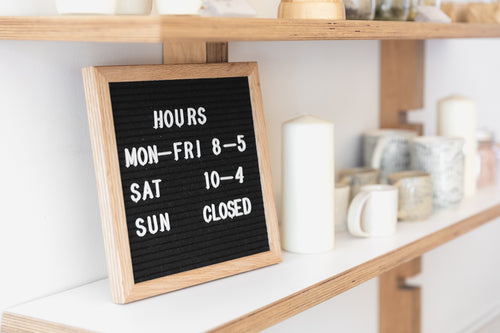 a letter board displays opening times on a shop shelf