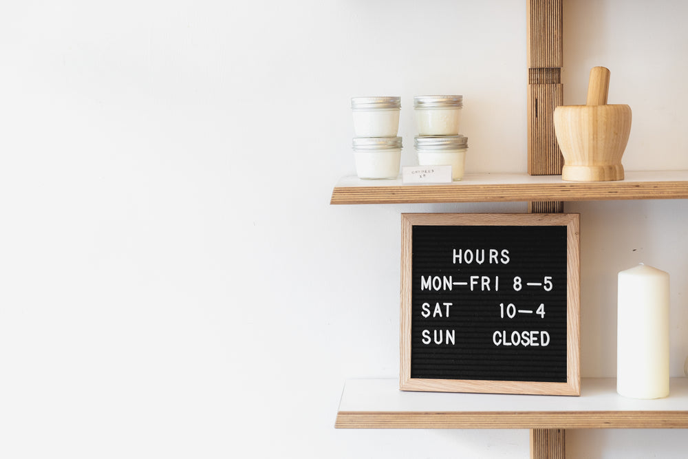 a letterboard on a busy shop shelf denotes opening times