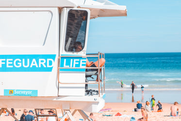 a lifeguard sits in raised white stand