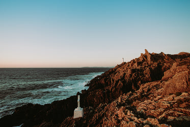 a lighthouse sits on top of a cliff