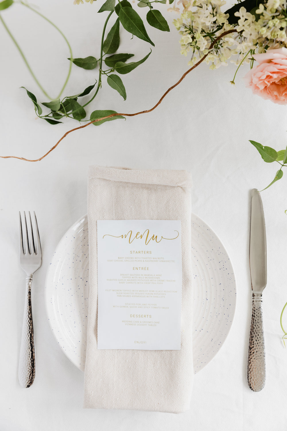 a linen napkin topped with a gold-lettered menu