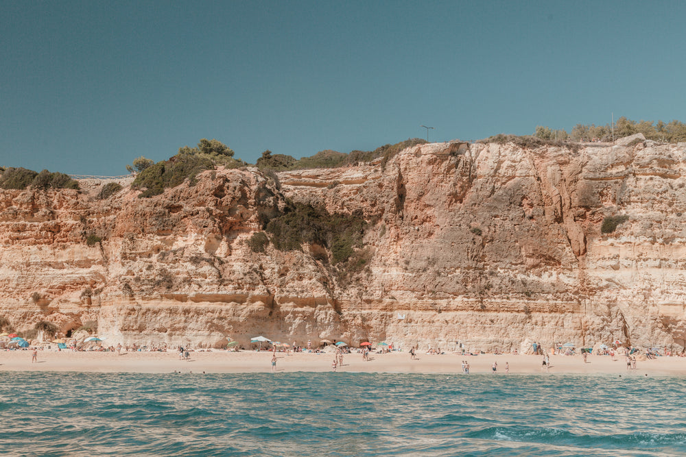 a long stretch of sandy beach under weather limestone cliffs