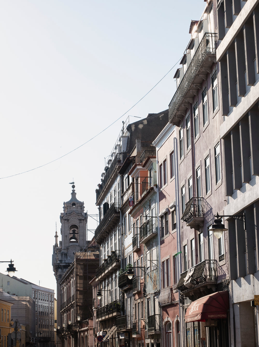 a look up to the clear sky above a row of old buildings