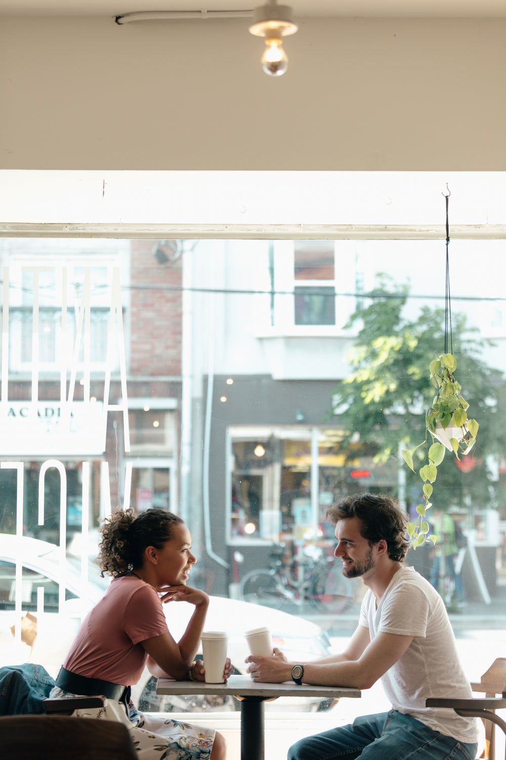 a man and a woman are framed against a sunny window