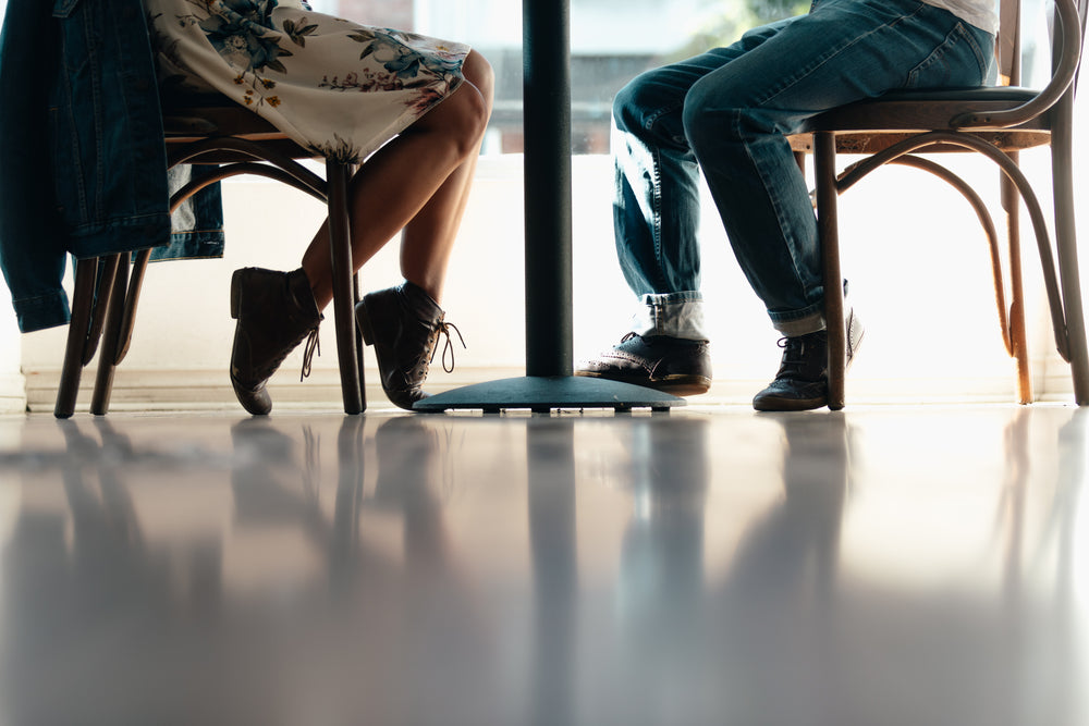 a man and a woman's feet under a table