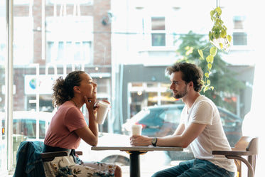 a man and a woman share a smile over coffee