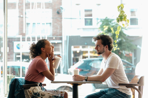 a man and a woman share a smile over coffee