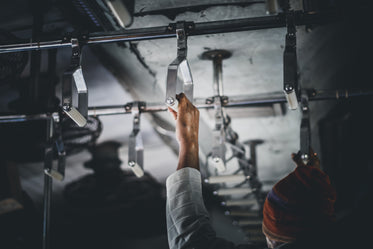 a man grabs a metallic handle hanging from the ceiling