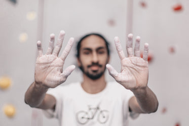 a man holding out chalk covered hands