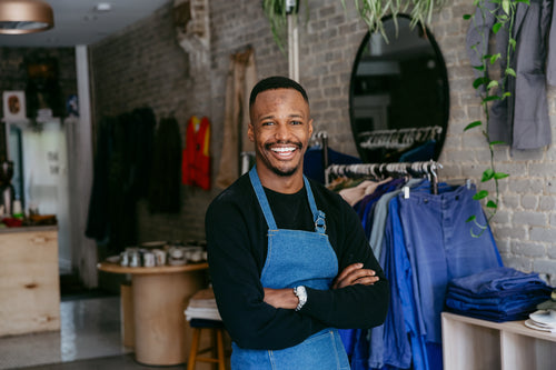 a man in denim apron smiles for the camera