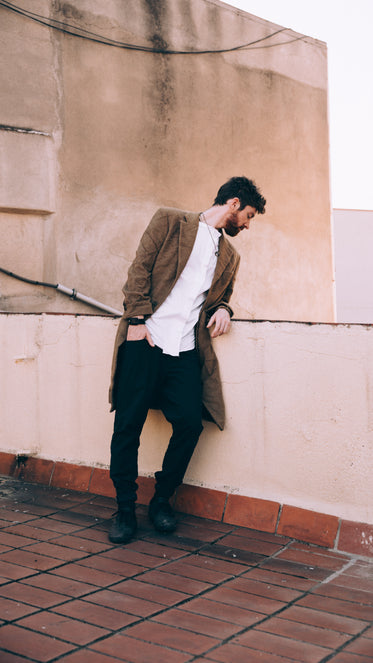 a man looks to the street below from a rooftop