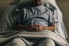 a man propped up in hospital bed with hands crossed