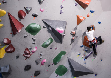 a man scales a climbing route