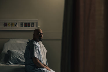 a man sits on his hospital bed and stares into the distance