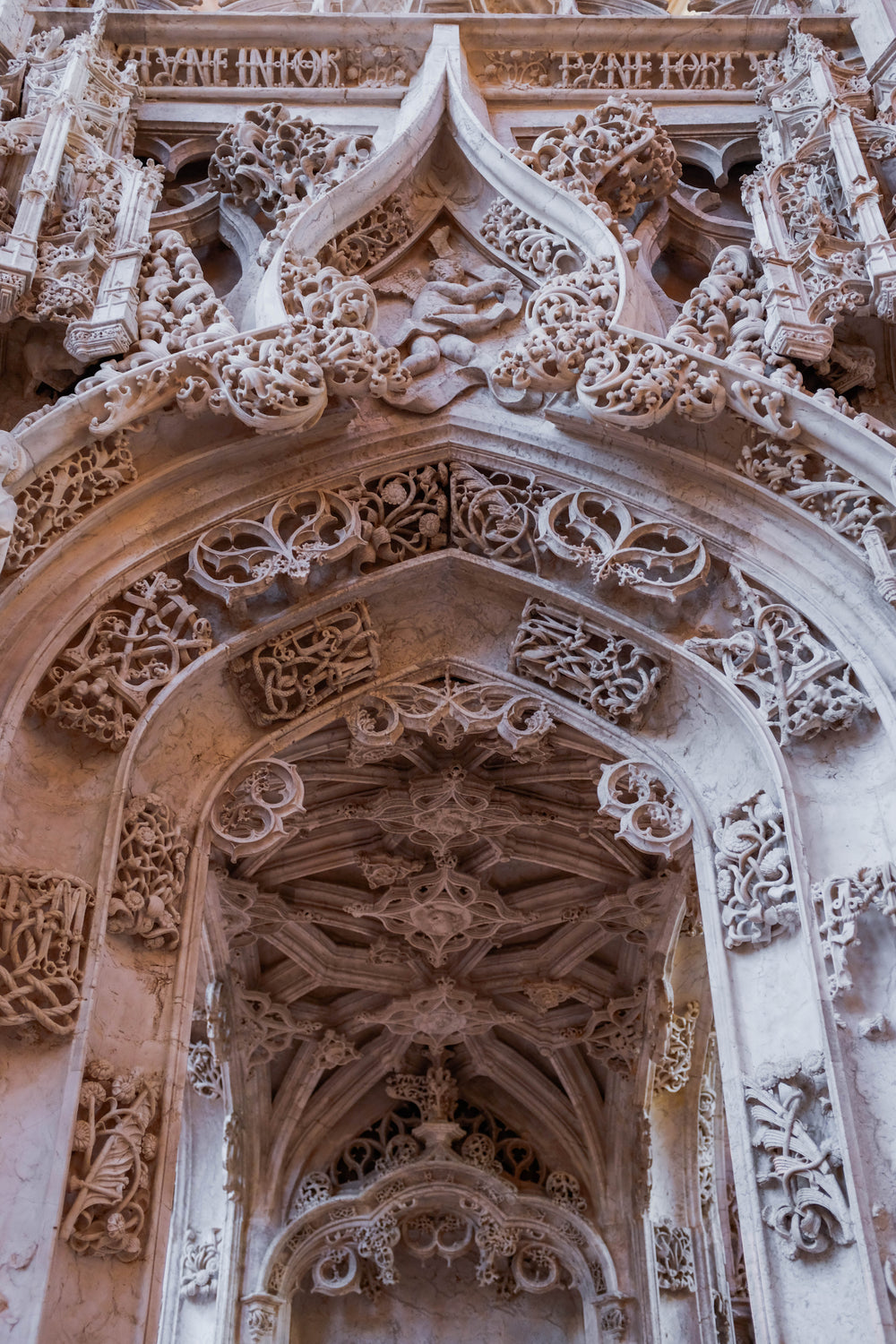a marble archway with figures hewn into it