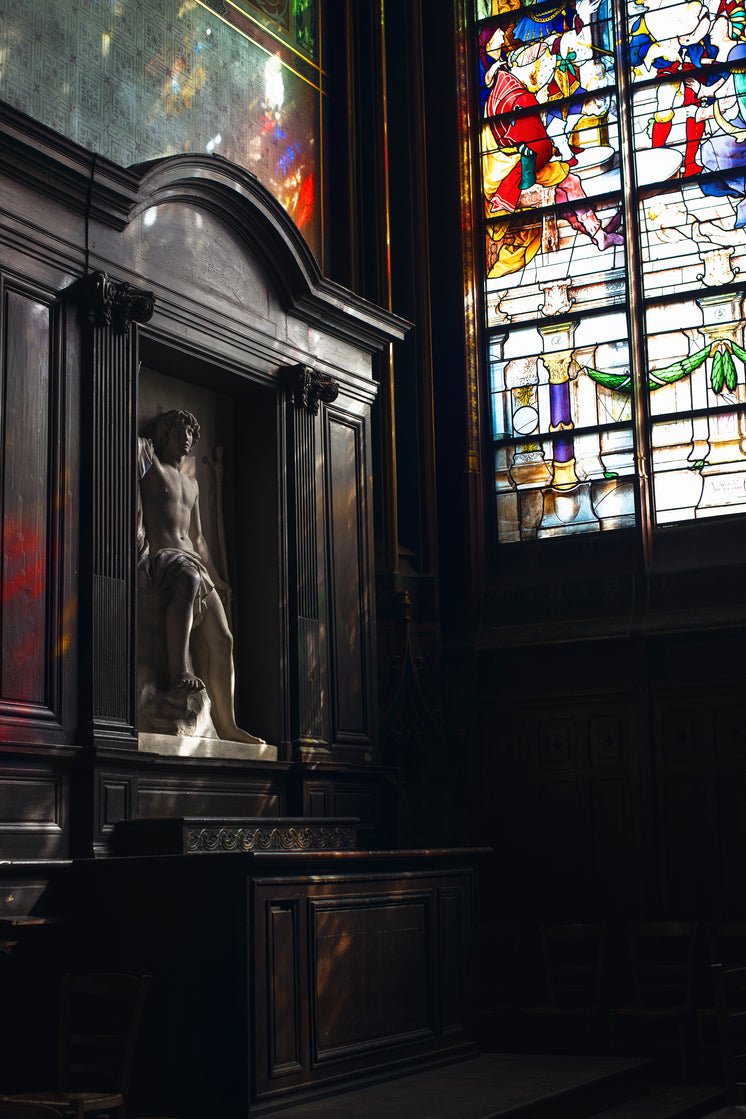 A Marble Statue Of A Man In A Little Wooden Niche