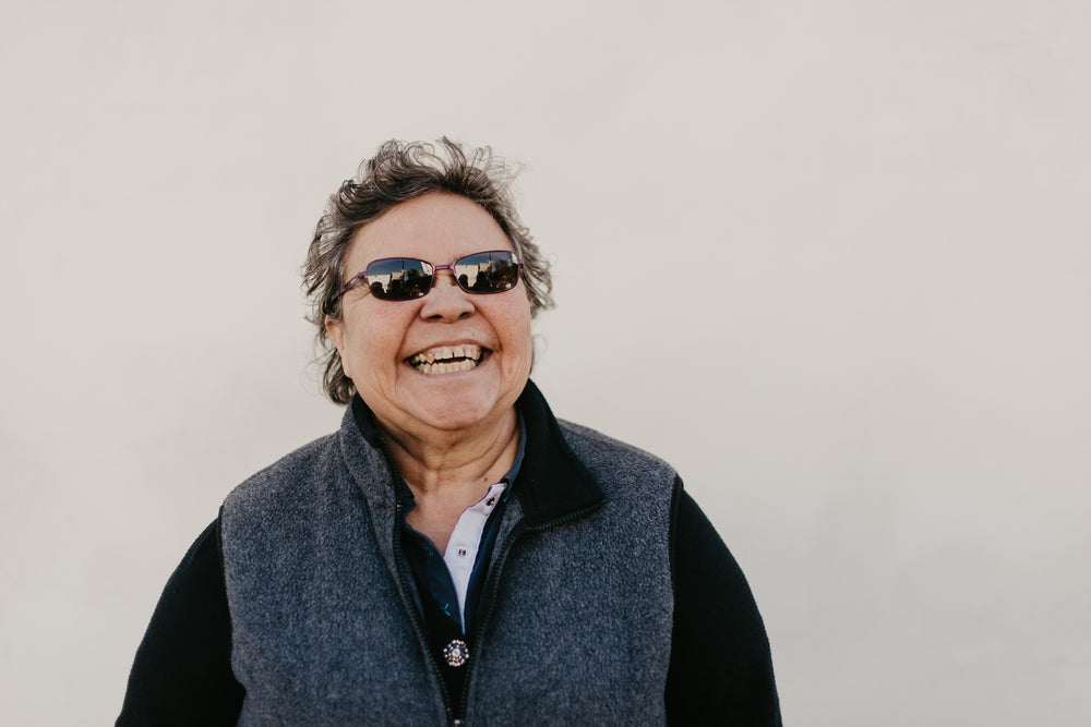 a mature woman with sunglasses laughing