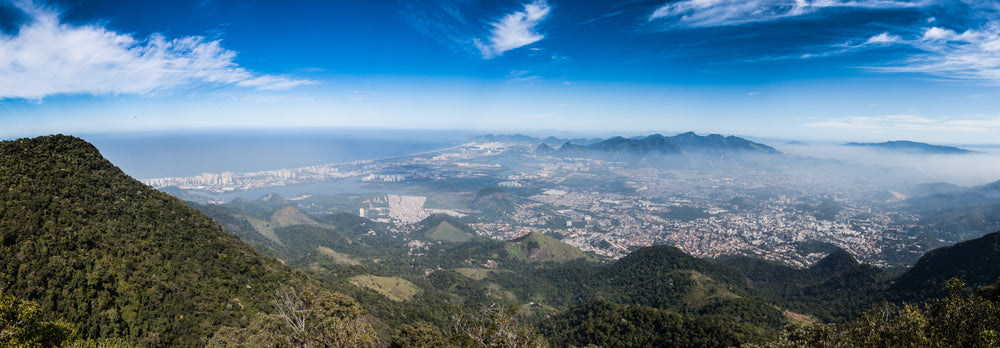 a misty city nestled between mountains on a sunny day