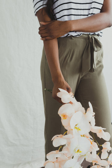 a model in khakis holding orchids