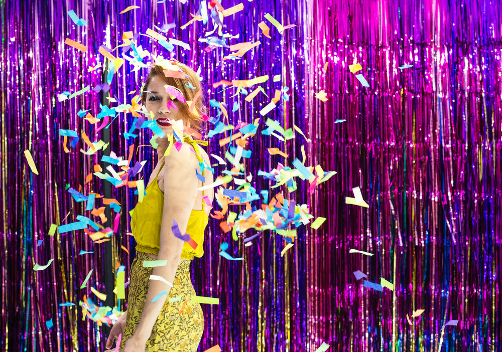 a model smiles through a shower of confetti