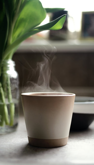 a mug sits on a countertop with steam coming out of it