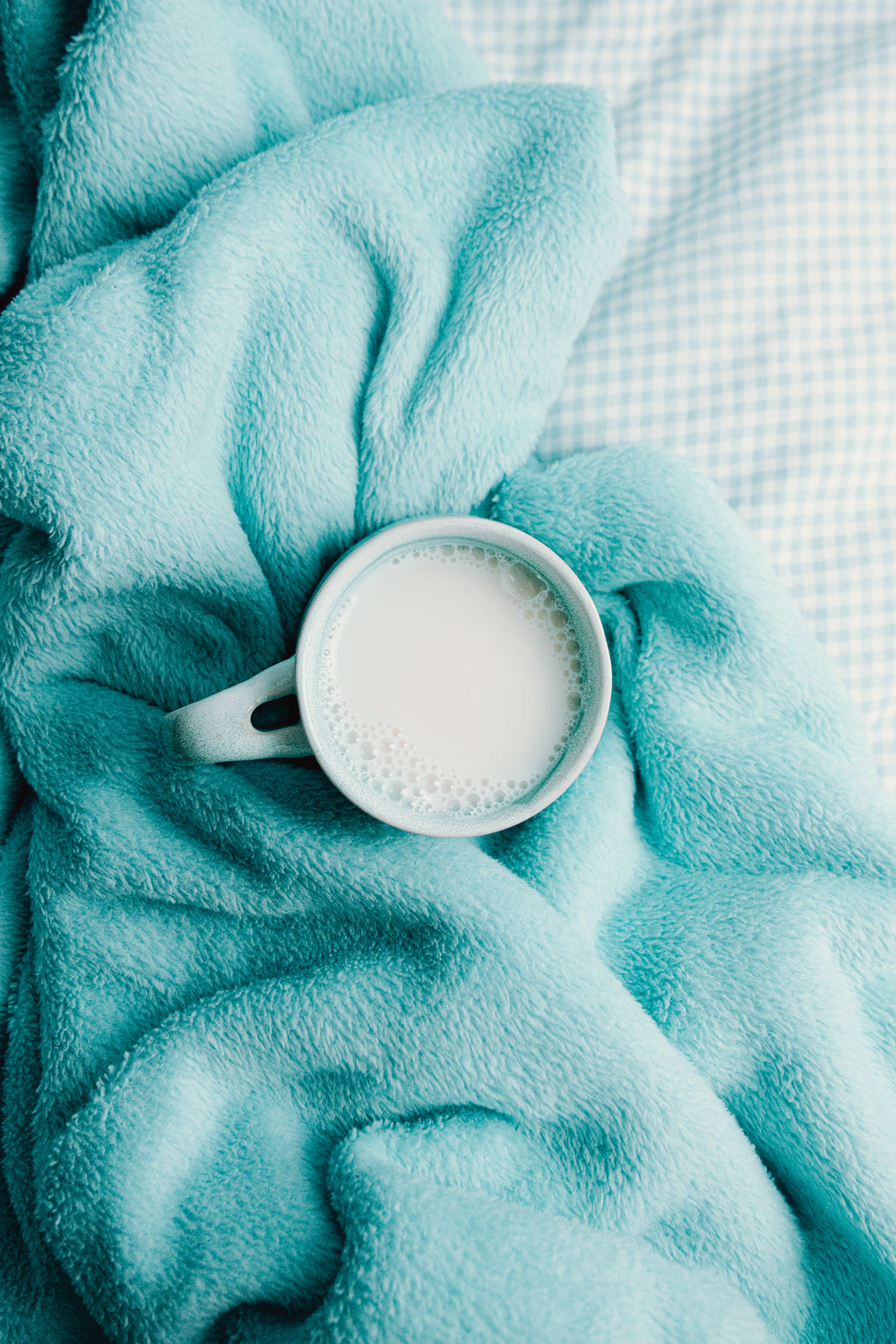 a mug surrounded by a soft blue blanket