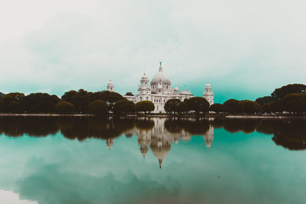 a palace by a lake lined by trees