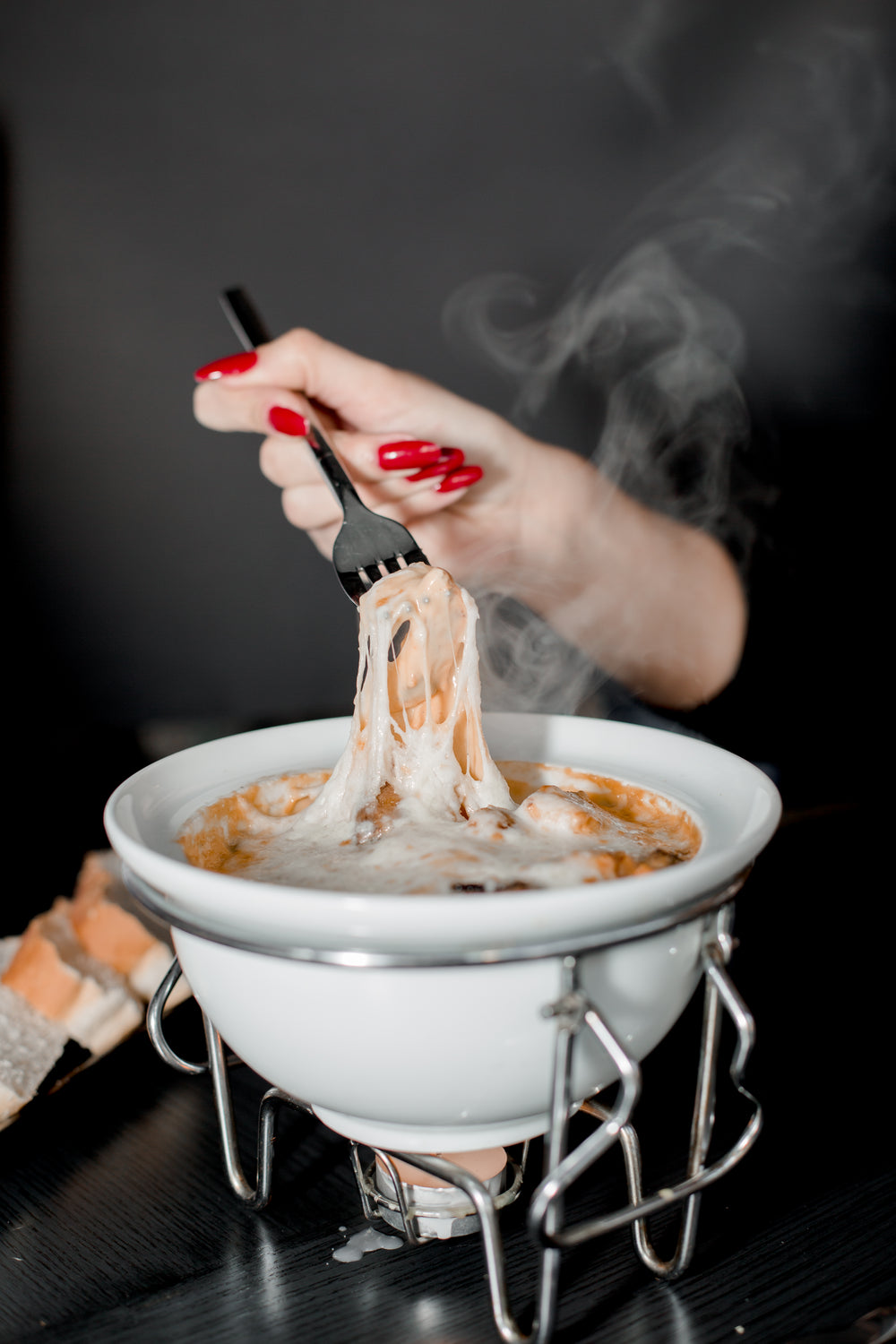 a person enjoys cheesey fondue