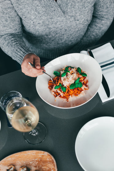 a person gets ready to eat a beautiful bowl of pasta