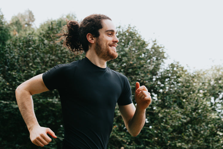 A Person In Black Smiling As They Run Outdoors