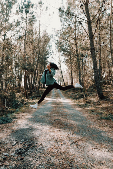 a person mid jump on a country road