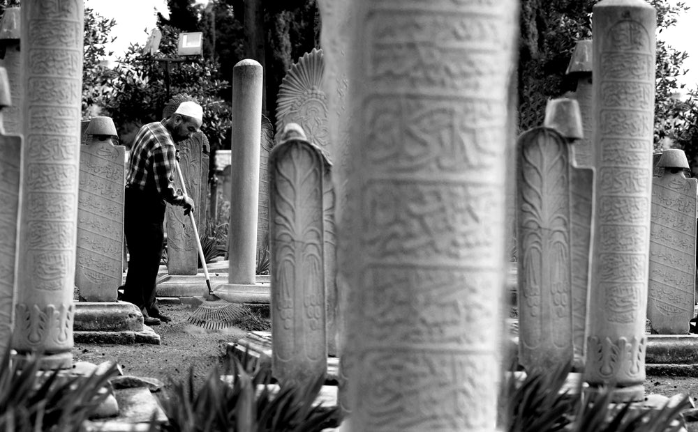 a person raking the ground in black and white