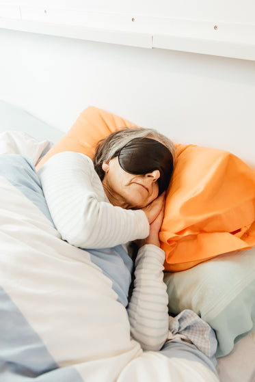 a person sleeps with a black eye mask on