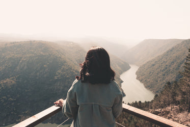 a person standing at a corner taking in the forest view