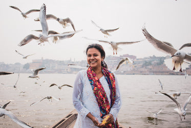 a person surrounded by birds smiles for the camera