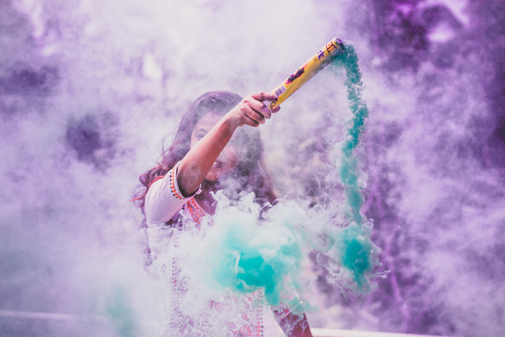 a person surrounded by purple and blue smoke