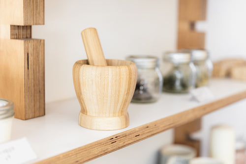 a pestle and mortar on a wooden shelf