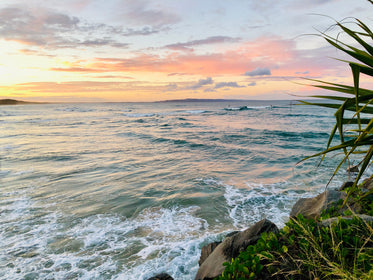 a pink evening sky over blue waves at the coast