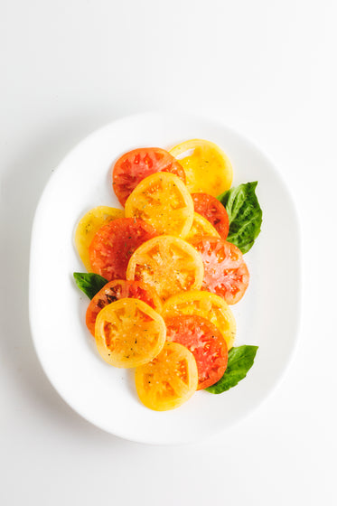 a plate of sliced tomatoes and basil