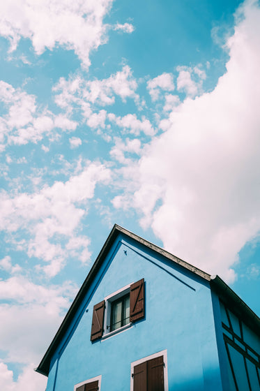 a powder blue home under a blue sky