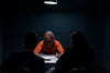 a prisoner in an interrogation room glares at detectives