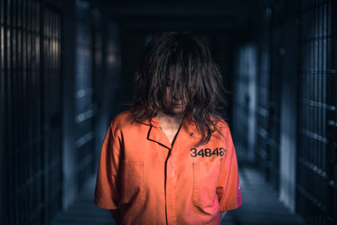 a prisoner standing in orange jumpsuit