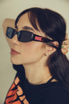 a profile of a woman in bold black sunglasses