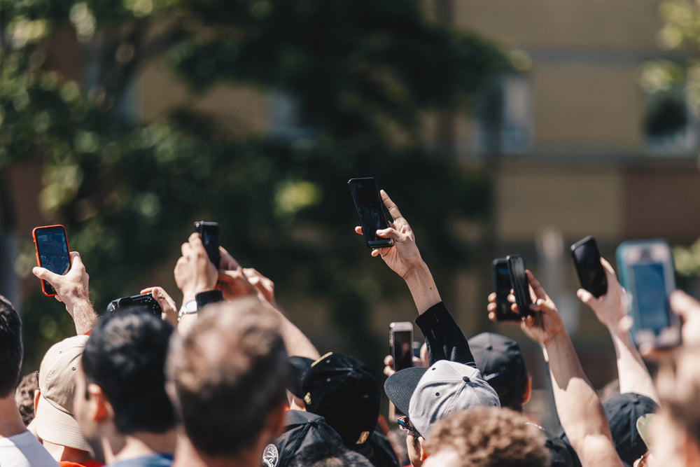 a protest in the street holds up mobile phones