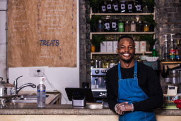 a proud store owner standing by their counter