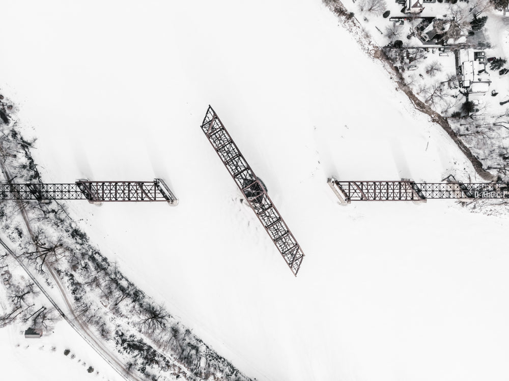 a railway swing bridge on a frozen river covered in snow
