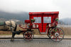 a red and white carriage with a horse attached to it